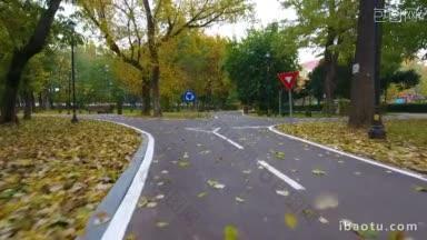 航拍到的城市公园里秋天落叶下骑自行车的人的路标